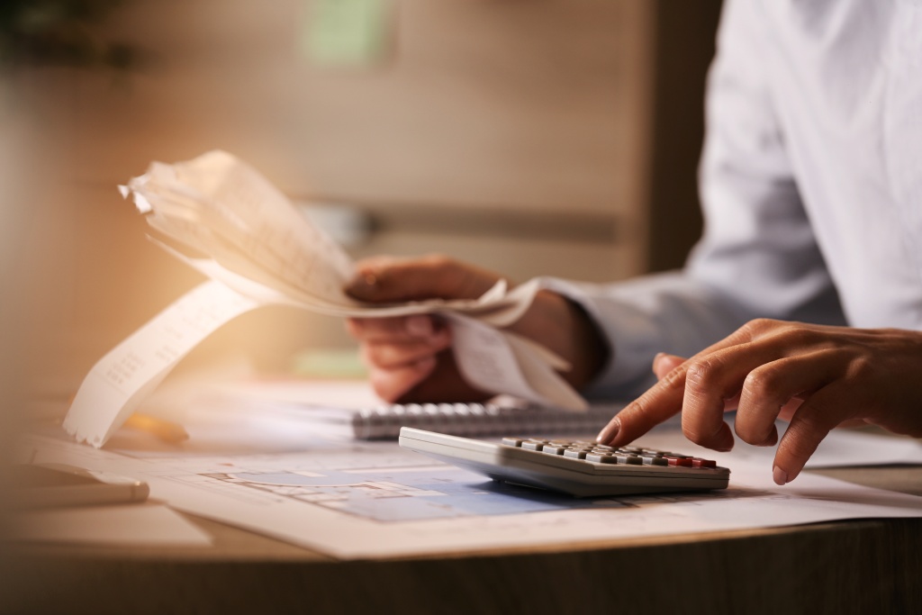 closeup-economist-using-calculator-while-going-through-bills-taxes-office.jpg бумаги